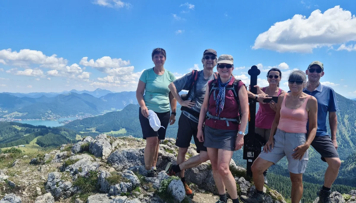 Sechs Wanderer auf dem Gipfel des Fockenstein mit Bergpanorama und blauem Himmel | © Sylvia Summerer