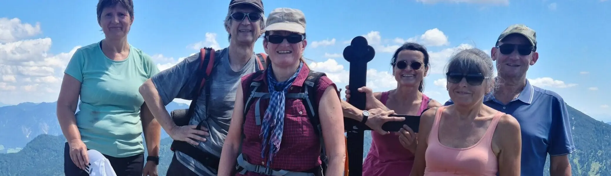Sechs Wanderer auf dem Gipfel des Fockenstein mit Bergpanorama und blauem Himmel | © DAV Sektion Geltendorf