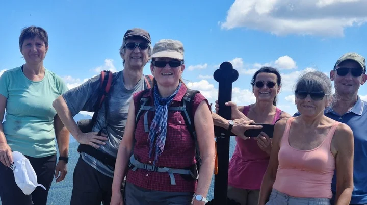 Sechs Wanderer auf dem Gipfel des Fockenstein mit Bergpanorama und blauem Himmel | © Sylvia Summerer