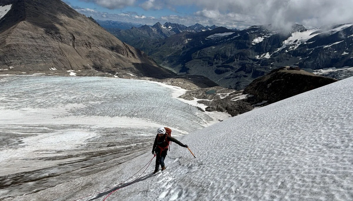 Bergsteiger mit Helm und Seil klettert auf schneebedecktem Gletscher in den Alpen unter bewölktem Himmel | © Steffen Wolf