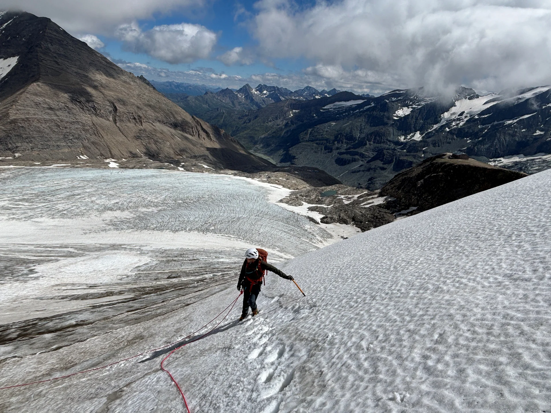 Bergsteiger mit Helm und Seil klettert auf schneebedecktem Gletscher in den Alpen unter bewölktem Himmel | © Steffen Wolf