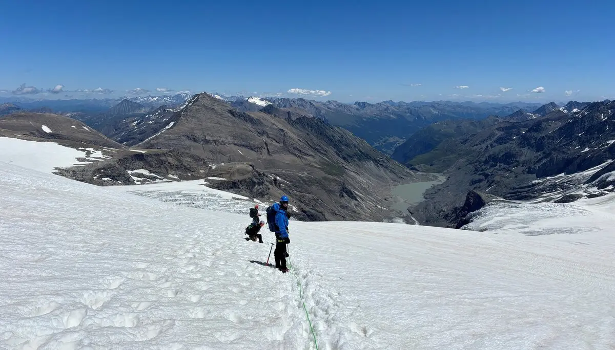 Zwei Bergsteiger mit blauer und schwarzer Kleidung steigen auf einem schneebedeckten Gletscher in den Alpen auf | © DAV Sektion Geltendorf