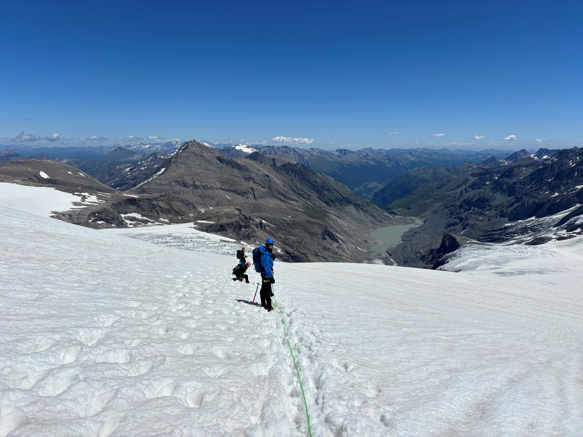 Zwei Bergsteiger mit blauer und schwarzer Kleidung steigen auf einem schneebedeckten Gletscher in den Alpen auf | © Steffen Wolf
