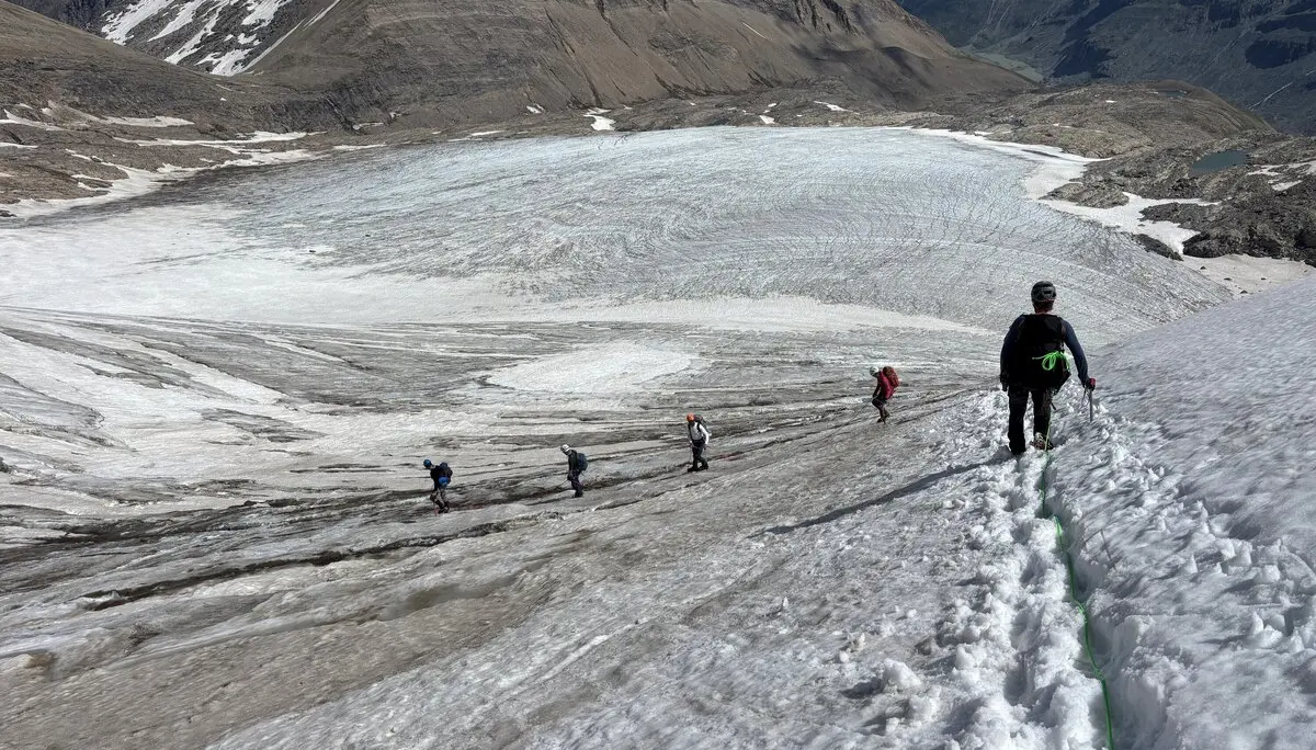 Fünf Bergsteiger steigen in einer Reihe auf einem schneebedeckten Gletscher in den Alpen auf, umgeben von felsigen Bergen | © DAV Sektion Geltendorf