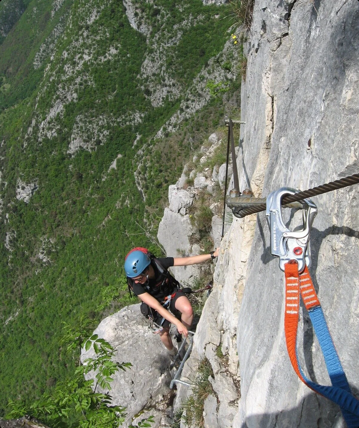Person mit Helm und Kletterausrüstung klettert an einem Klettersteig mit Stahlseil und Felswand  | © DAV Sektion Geltendorf