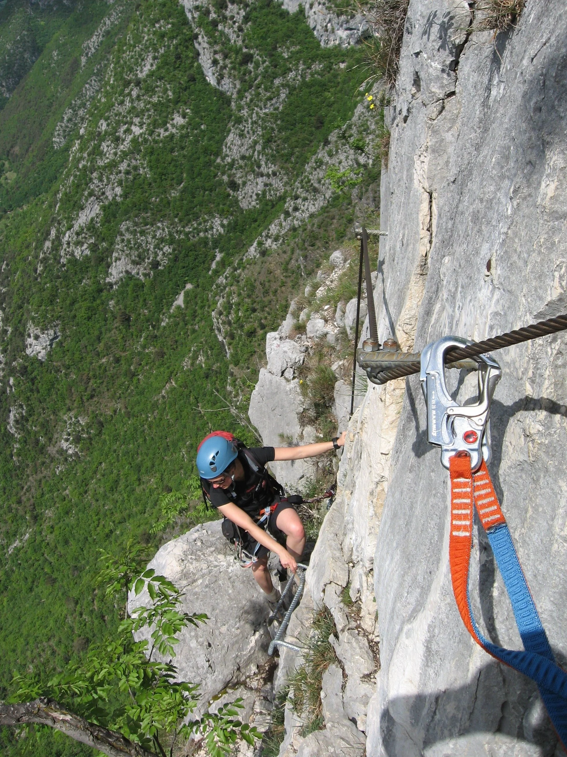 Person mit Helm und Kletterausrüstung klettert an einem Klettersteig mit Stahlseil und Felswand  | © DAV Sektion Geltendorf