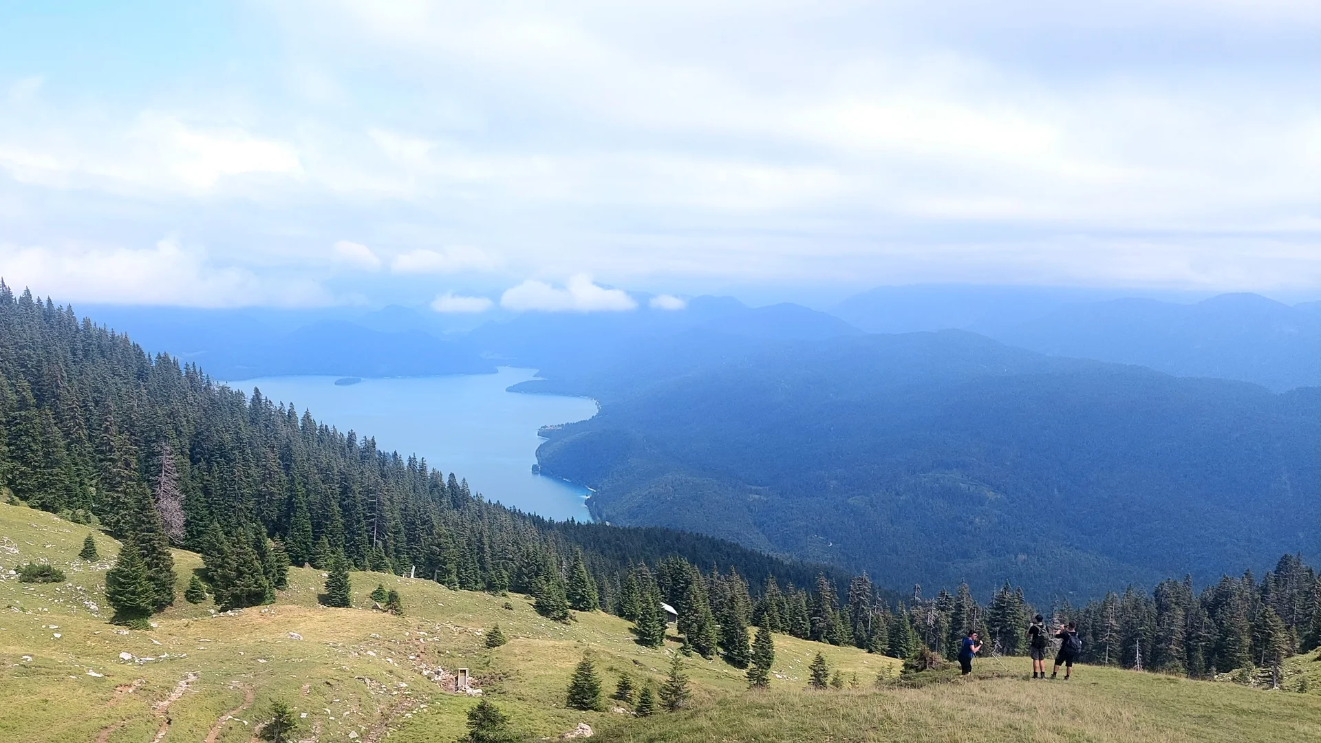 Blick vom Simetsberg auf bewaldete Hügel und einen langen See unter bewölktem Himmel | © DAV Sektion Geltendorf Blick vom Simetsberg auf bewaldete Hügel und einen langen See unter bewölktem Himmel | © DAV Sektion Geltendorf