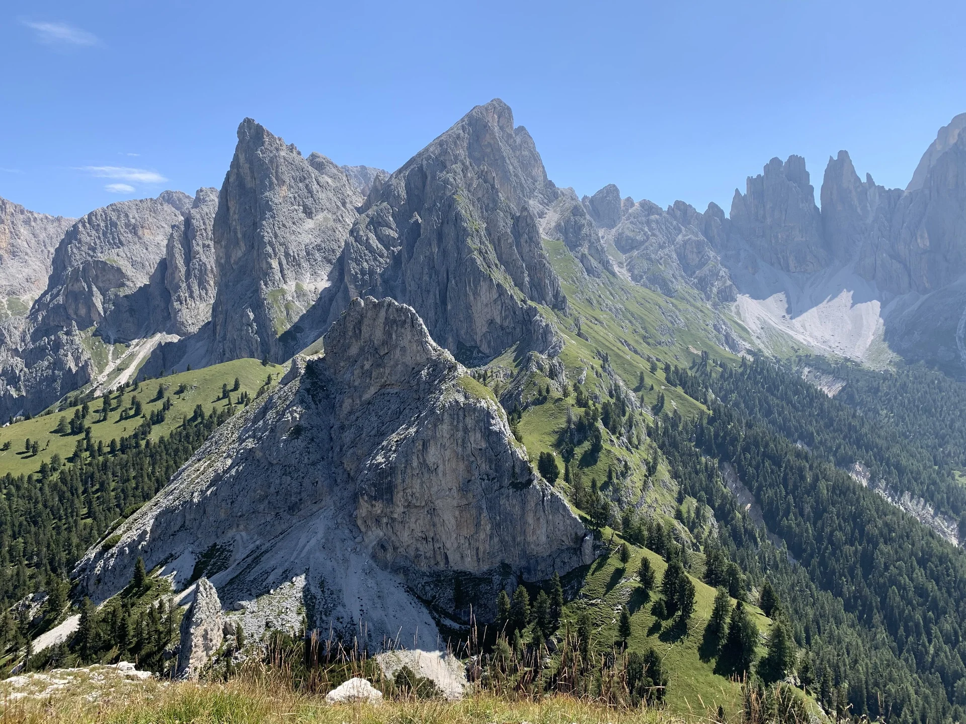 Berglandschaft mit schroffen Felsen und grünen Wiesen unter klarem blauem Himmel in den Dolomiten | © DAV Sektion Geltendorf