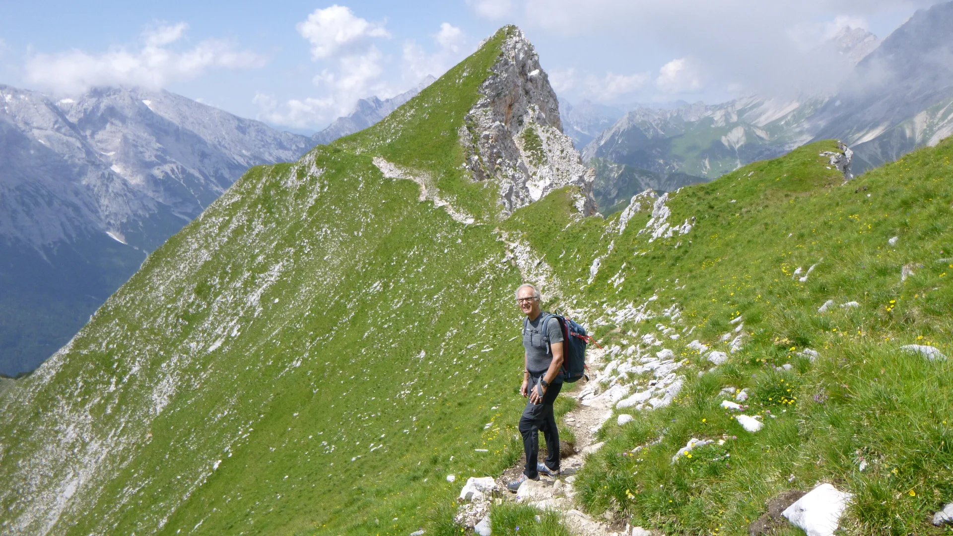 Gradwanderung Gehrenspitze mit Blick auf grünen Bergrücken im Hintergrund Berggipfel und bewölkter Himmel | © DAV Sektion Geltendorf Gradwanderung Gehrenspitze mit Blick auf grünen Bergrücken im Hintergrund Berggipfel und bewölkter Himmel | © DAV Sektion Geltendorf