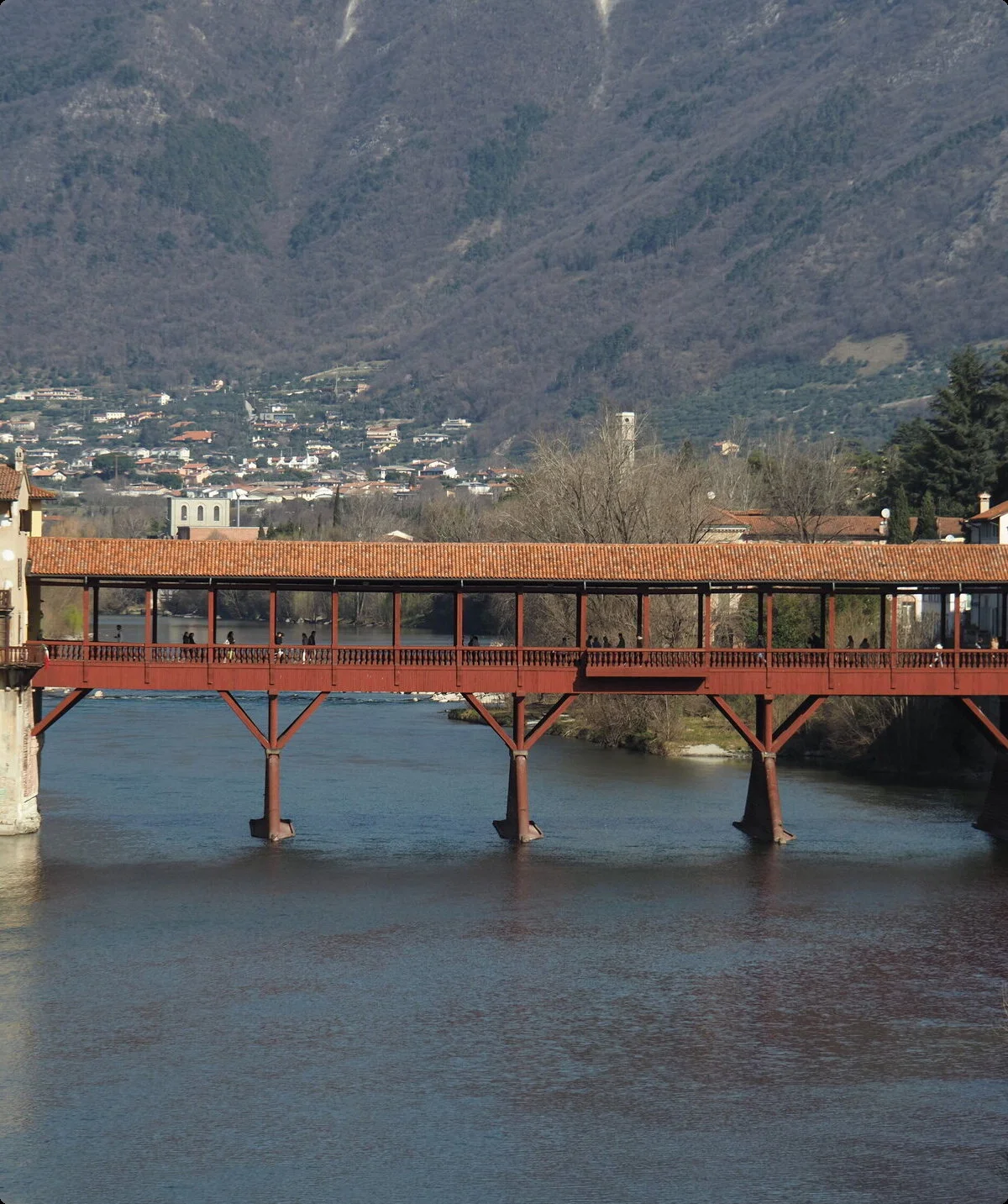 Ponte Vecchio, Bassano del Grappa, Italien: Historische Holzbrücke über den Fluss Brenta mit Blick auf die Stadt und die Berge im Hintergrund. Wahrzeichen und Touristenattraktion. | © Christoph Maier