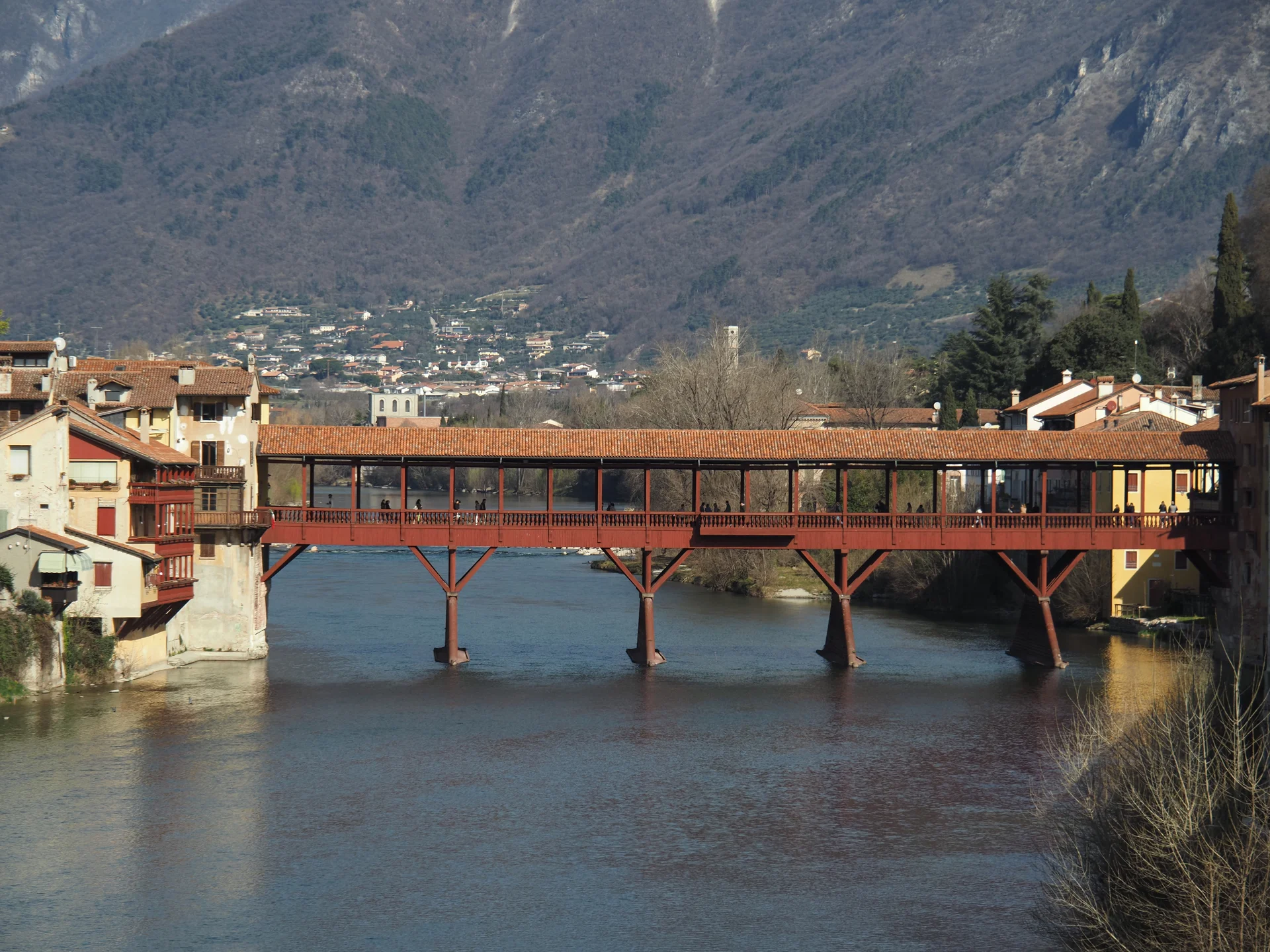 Ponte Vecchio, Bassano del Grappa, Italien: Historische Holzbrücke über den Fluss Brenta mit Blick auf die Stadt und die Berge im Hintergrund. Wahrzeichen und Touristenattraktion. | © Christoph Maier