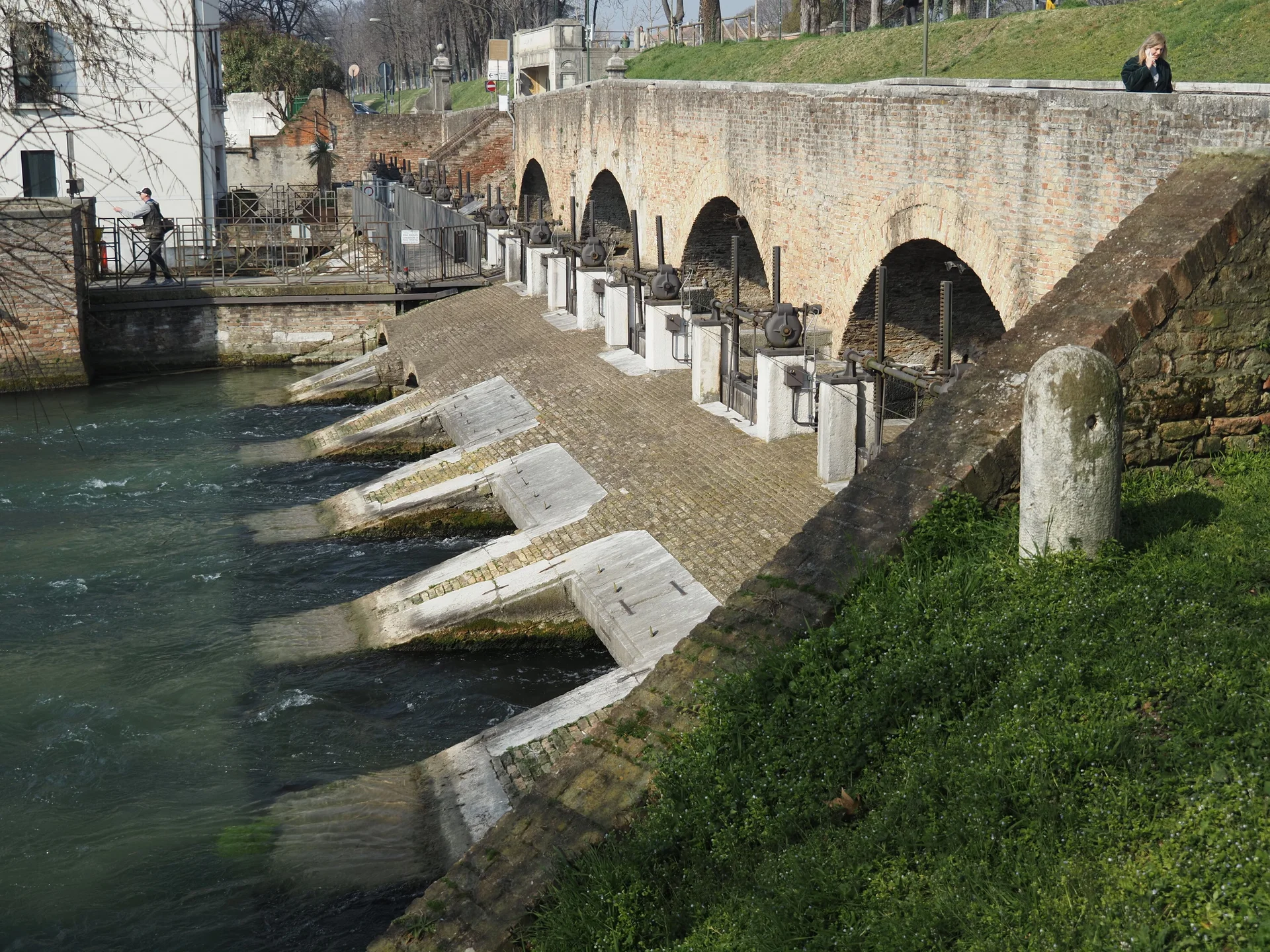 Historische Schleuse mit Backsteinbrücke in Italien. Fluss mit Wasserwehren und antiken Bauwerken. Sehenswürdigkeit und Tourismus in Italien. Flusslandschaft mit Schleusentor. | © Christoph Maier