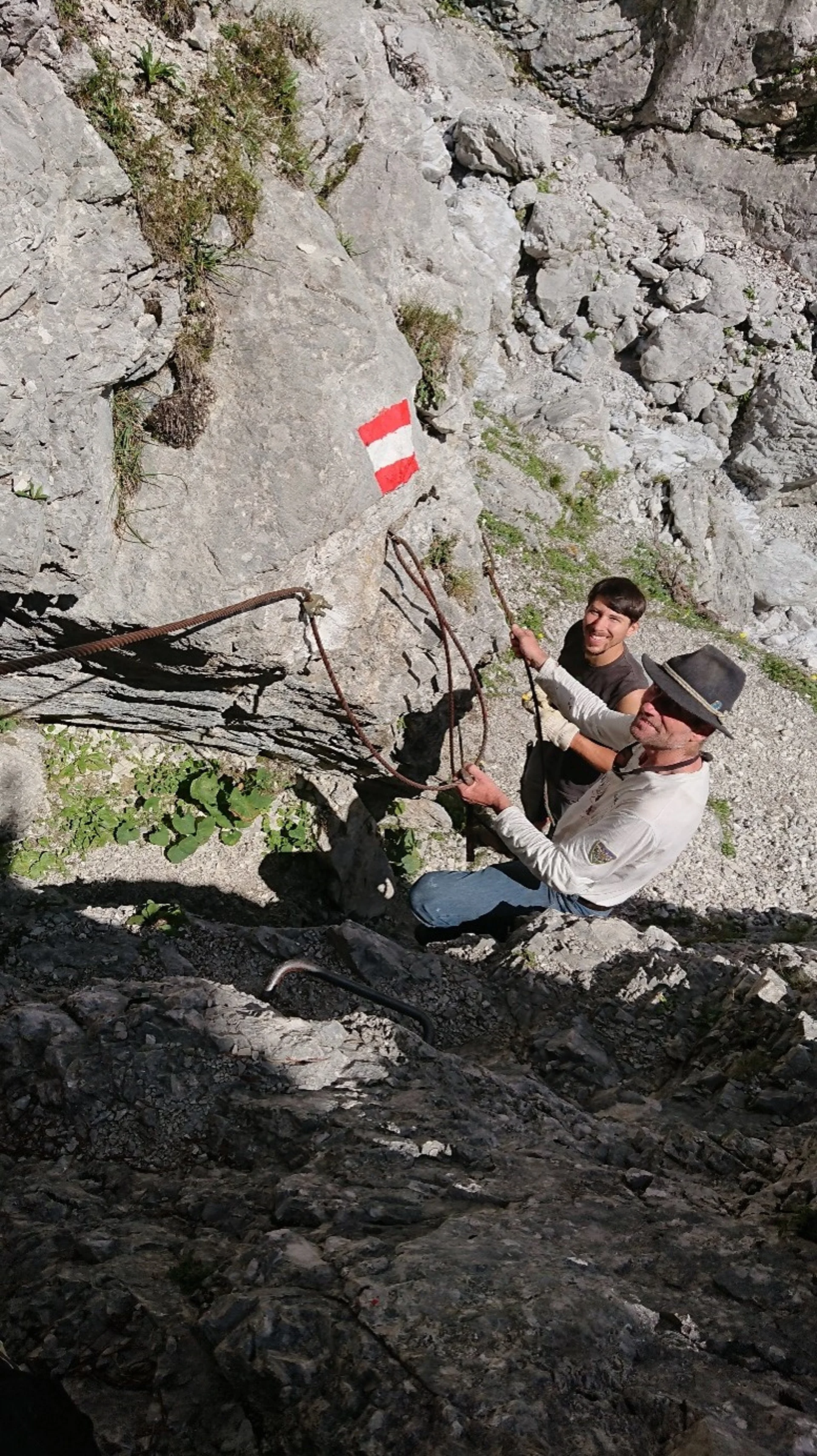 Zwei Bergsteiger klettern an einer felsigen Steilwand mit rotem und weißem Wanderwegzeichen | © Sektion Geltendorf