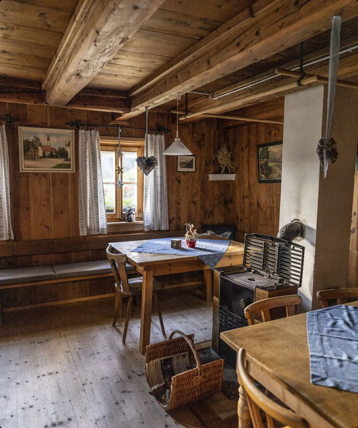 Gemütlicher Gastraum der Neuen Magdeburger Hütte mit Holztischen, blauen Tischdecken, Holzverkleidung und einer an der Wand hängenden Gitarre | © DAV/Wolfgang Ehn
