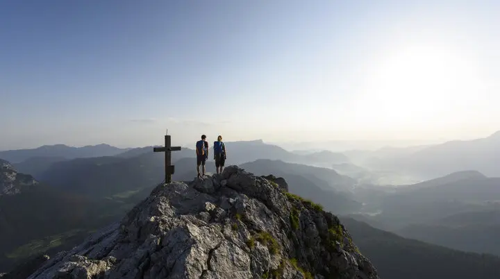 Auf dem Gipfel: Zwei Wanderer aus der Ferne auf eine Berggipfel | © DAV/Wolfgang Ehn
